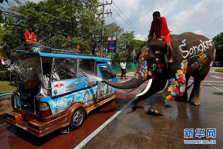 在泰国大城府的宋干节庆祝活动上，大象把水喷到游客身上。