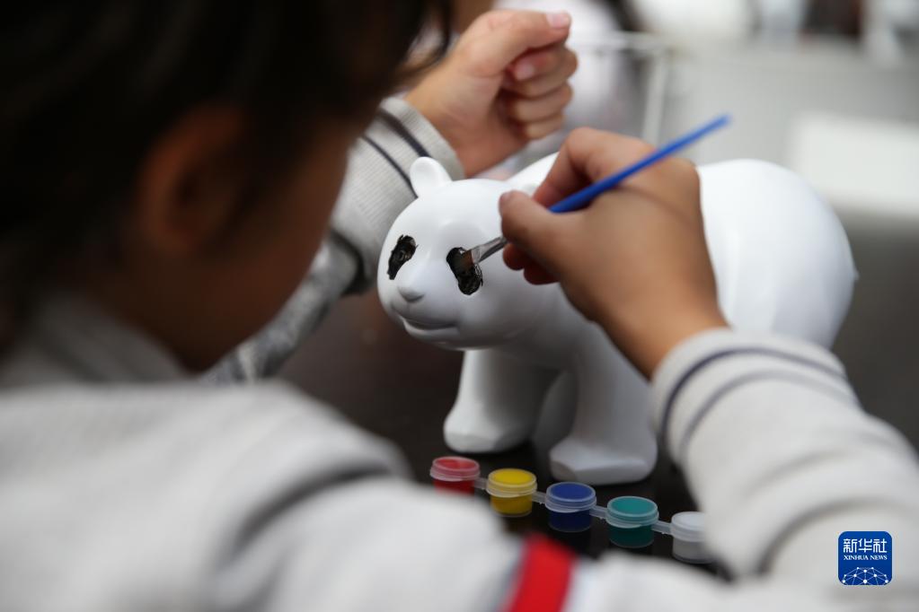 8月6日，在比利时布吕热莱特的天堂动物园，儿童在大熊猫三岁生日庆祝活动中为熊猫玩偶上色。新华社记者 郑焕松 摄