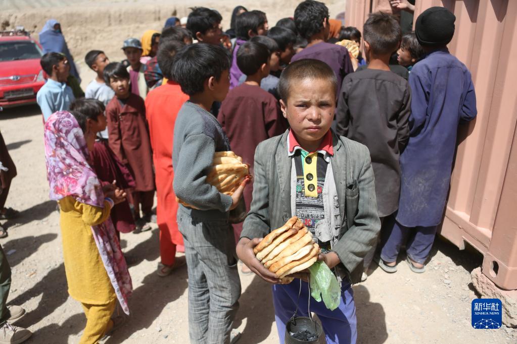 7月13日，阿富汗巴米扬儿童参加文物保护知识培训后领到食物。