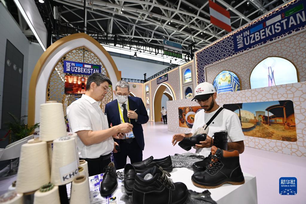 8月14日，参观者在第六届丝绸之路国际博览会主宾国乌兹别克斯坦展区上了解当地特色商品。