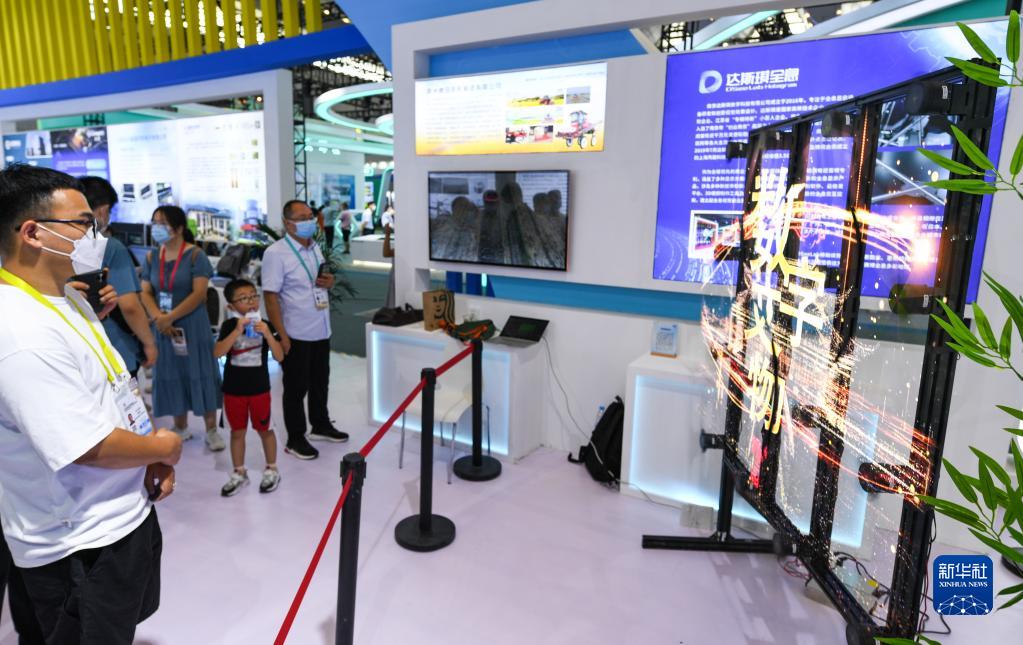 8月14日，在西安国际会展中心中国馆，参观者在观看全息显示设备。