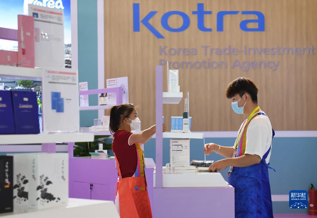8月14日，西安国际会展中心国际馆韩国展区的店员在整理商品。