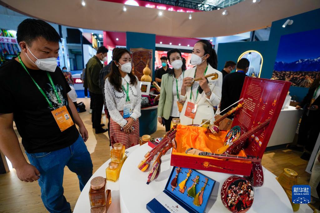9月20日，在第七届中国－亚欧博览会“丝路古龟兹 神奇阿克苏”展位上，参展商向参观者介绍手工艺品。新华社记者 赵戈 摄