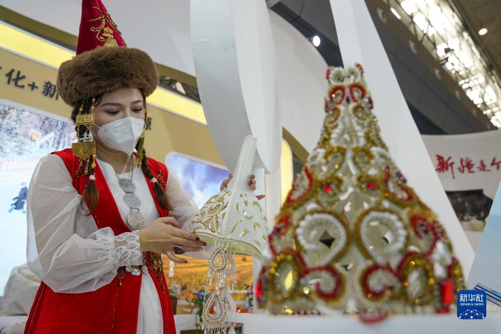 9月21日，在第七届中国－亚欧博览会上，“新疆是个好地方”展位的工作人员在整理哈萨克族花帽。新华社记者 丁磊 摄