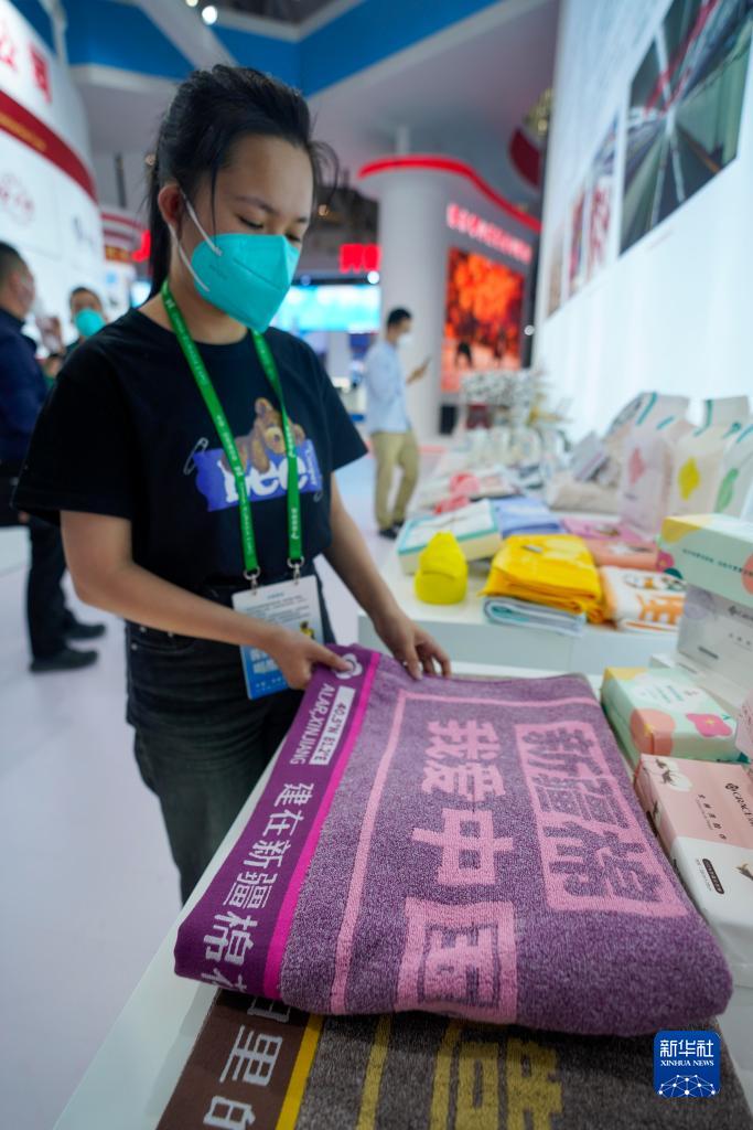 9月20日，在第七届中国－亚欧博览会上，参展商在整理由阿拉尔市所产的棉花加工而成的毛巾制品。新华社记者 李响 摄