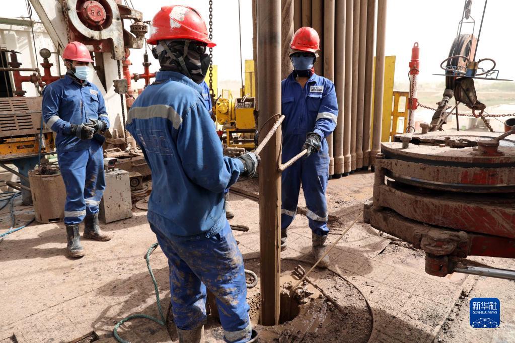 9月25日，伊拉克工人在米桑省哈法亚油田内的一个钻井平台上工作。新华社发（哈利勒·达伍德摄）