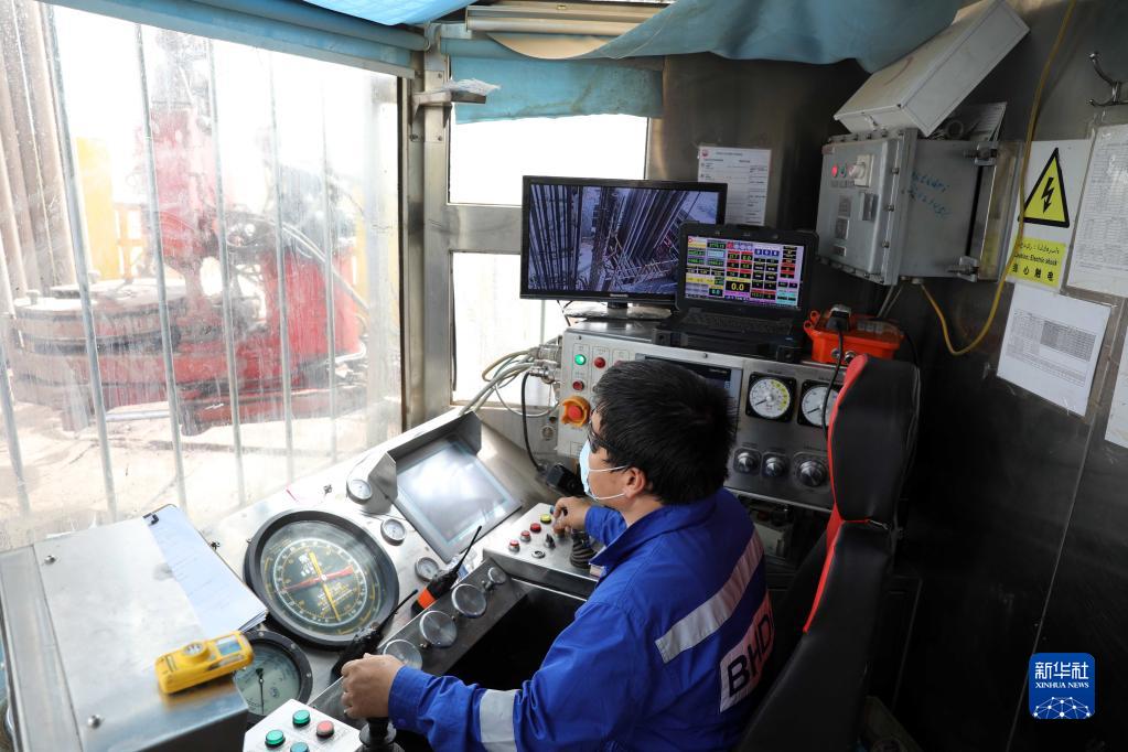9月25日，中国工程师在伊拉克米桑省哈法亚油田内的一个钻井平台控制室内工作。新华社发（哈利勒·达伍德摄）