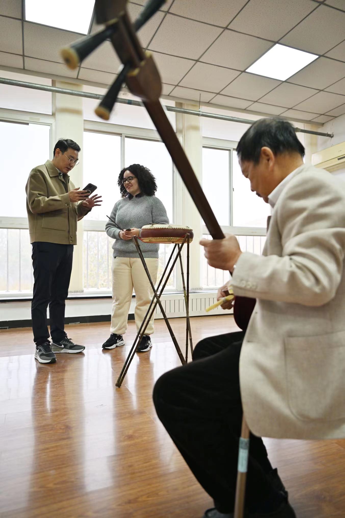 11月20日，在南开大学的一间教室内，艾茉莉（中）和师父王文磊（左一）练习京东大鼓。新华社记者 李然 摄