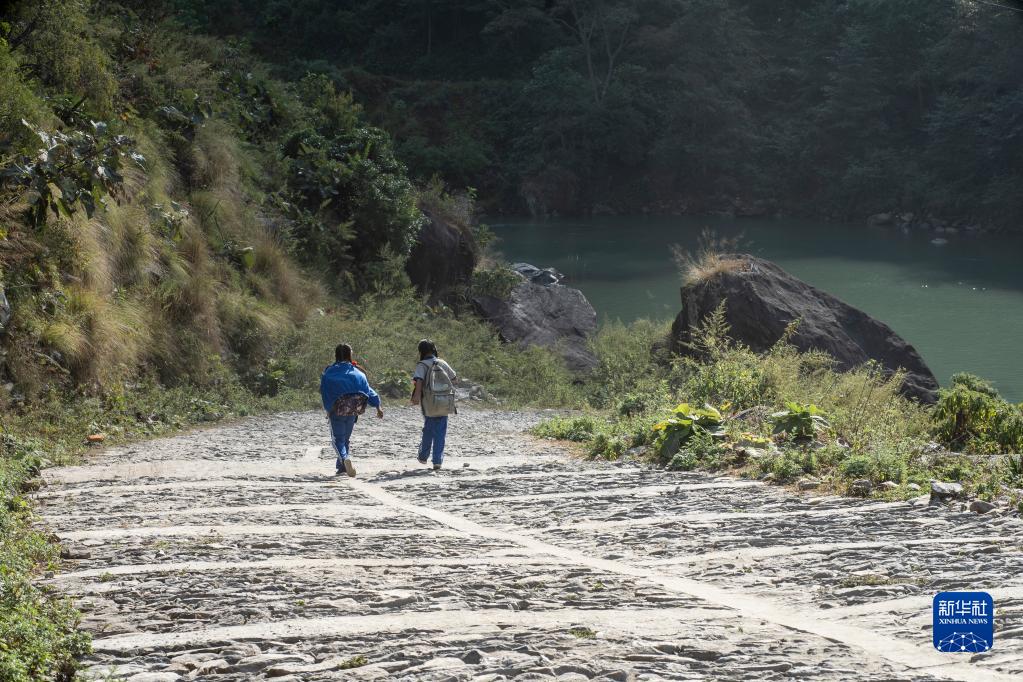 11月8日，尼泊尔勒姆宗县村民走在水电站项目公司帮助修缮的道路上。新华社发（哈里·马哈尔詹摄）