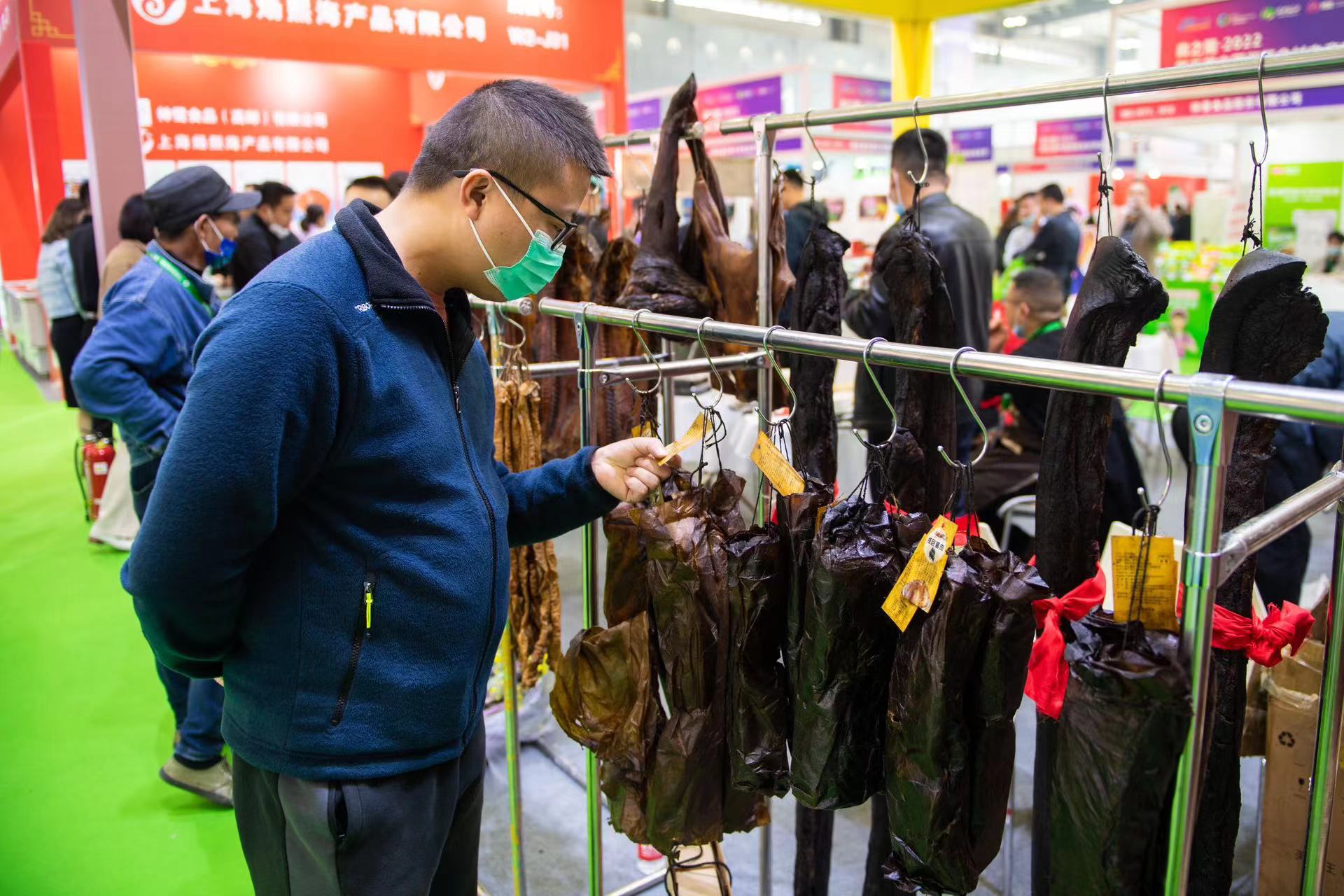 11月24日，在长沙国际会展中心，观众在观看熏制的腊肉。新华社记者 陈思汗 摄