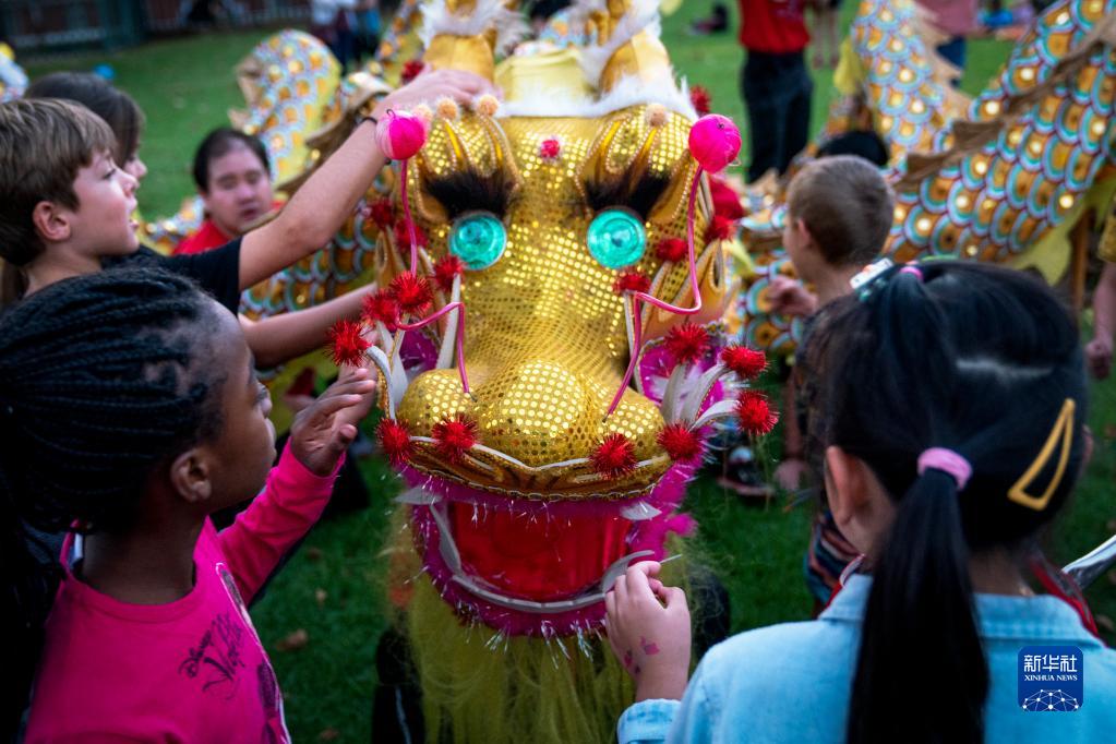 2月4日，在南非约翰内斯堡举行的元宵节及中国农历新年庆祝活动中，孩子们观察舞龙表演的“龙头”道具。新华社发（希拉兹·穆罕默德摄）