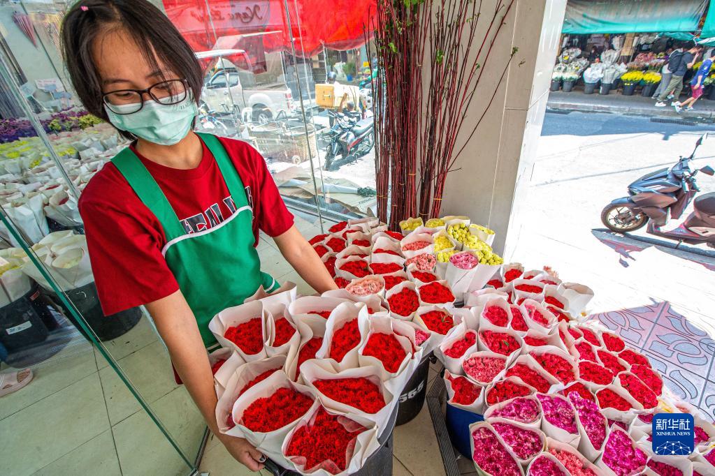 2月21日，工作人员在泰国曼谷帕空鲜花市场搬运来自云南的鲜花。新华社记者 王腾 摄