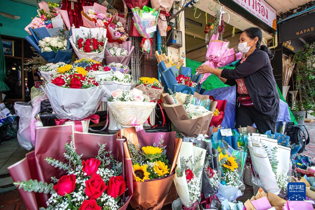 2月21日，商贩在泰国曼谷帕空鲜花市场手捧来自云南的鲜花。新华社记者 王腾 摄